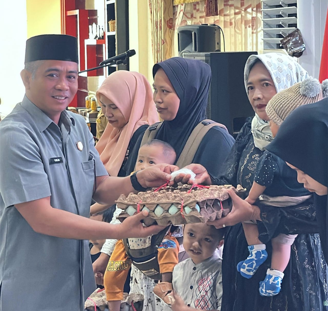 MOMEN: Ketua DPRD HSU H Fadilah, saat menyerahkan bantuan telur itik pada warga penerima manfaat HSU Ceria di Mess Negara Dipa, Kota Amuntai. (Foto: M.Akbar/Radar Banjarmasin)