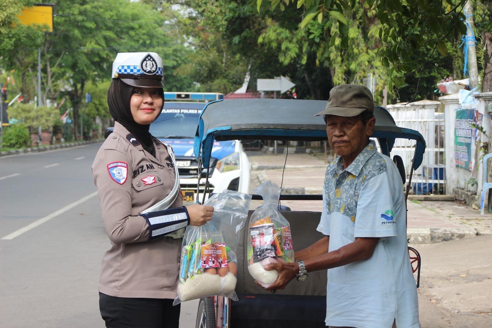 MOMEN: Bripda Fizah dari Lantas Polres HSU saat membagikan sembako kepada tukang becak di Kota Amuntai.