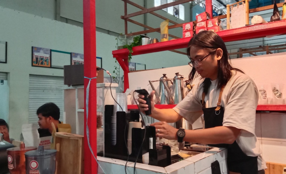 MERACIK: Barista Kopi Tjap Abah saat meracik kopi pesanan pelanggan di Pasar Bauntung Banjarbaru.