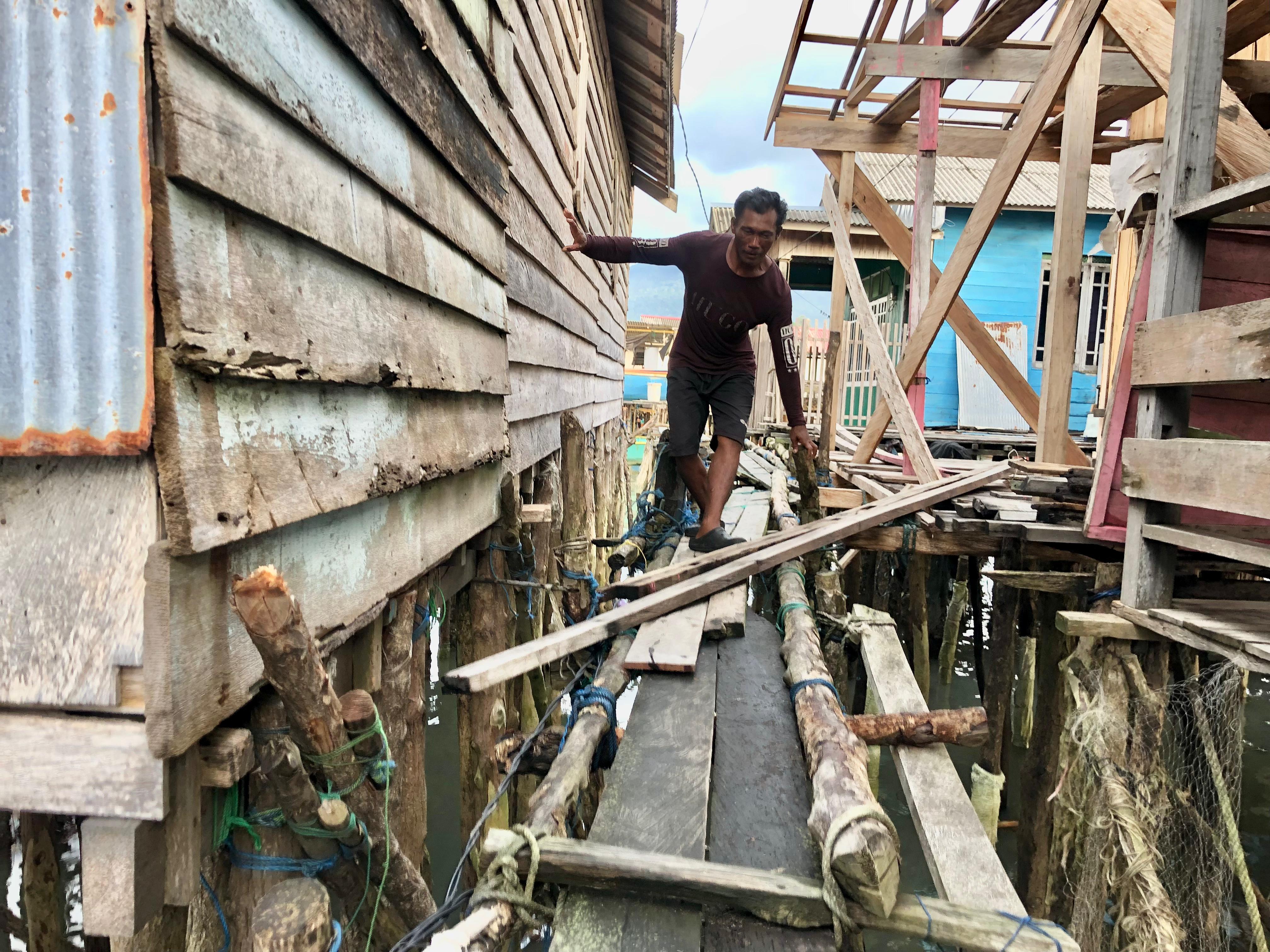 RAWAN AMBRUK: Situasi jembatan saat dilalui masyarakat yang penuh hati hati di Desa Rampa Kotabaru. Foto: Jumain/ Radar Banjarmasin.