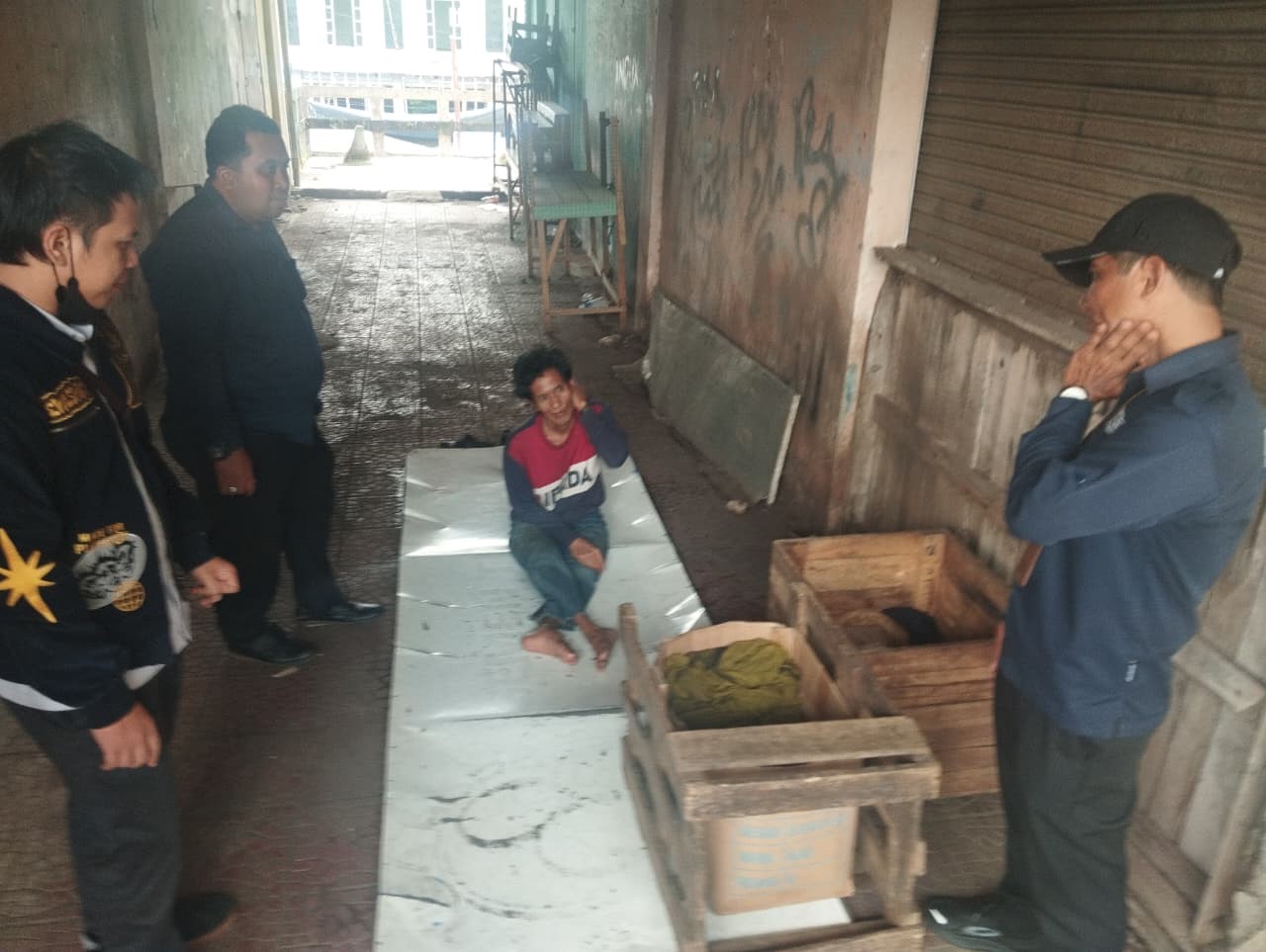 CEK LAPANGAN: Petugas Dinsos dan Perumda Pasar Bauntung Batuah Martapura, meninjau kondisi Zulkarnain (62) yang lumpuh dan tinggal di lorong lantai dua Martapura Plaza.