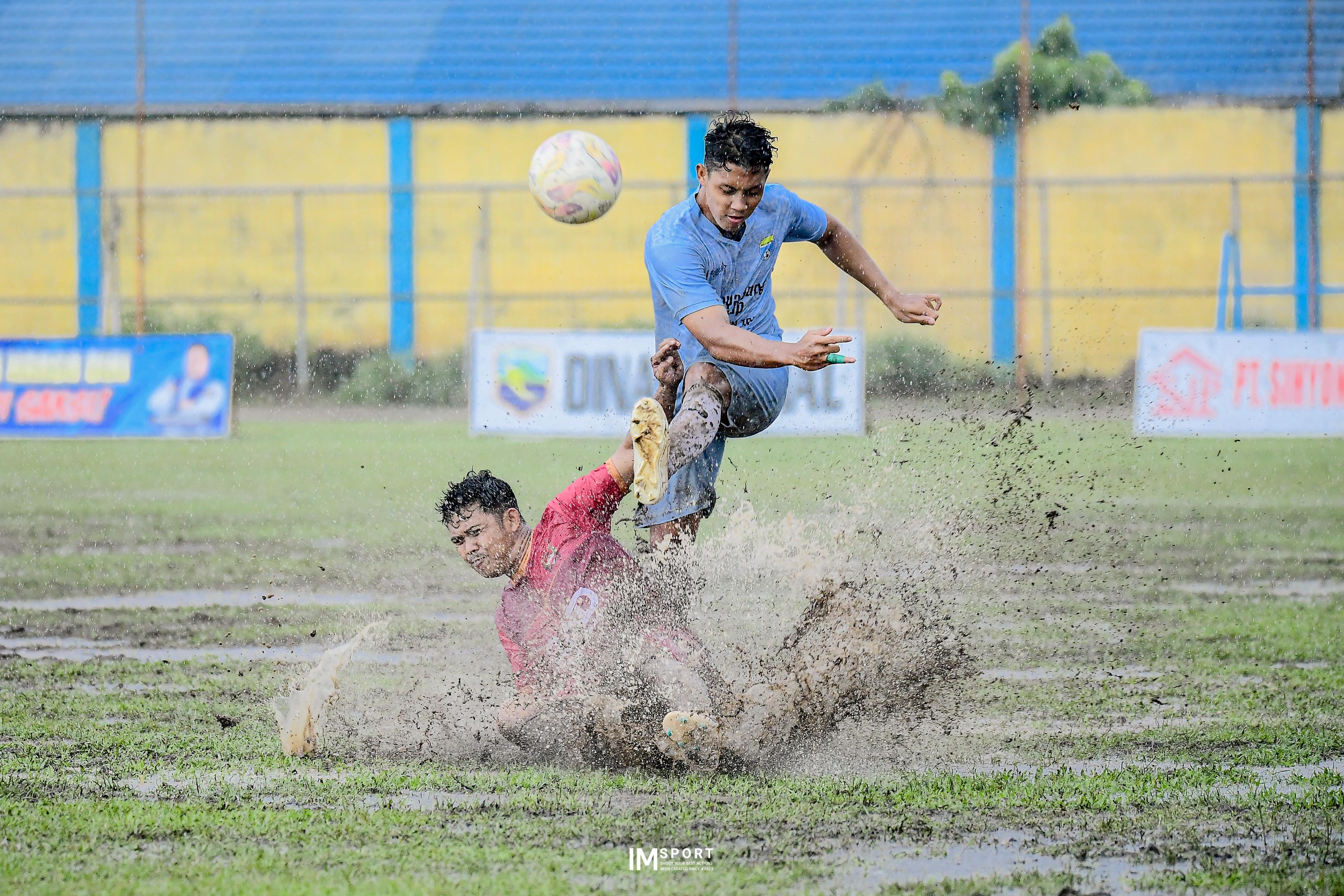 SENGIT: Pemain Surya Samudra FC (biru) menendang bola di atas pemain Bhayangkara FC (merah).