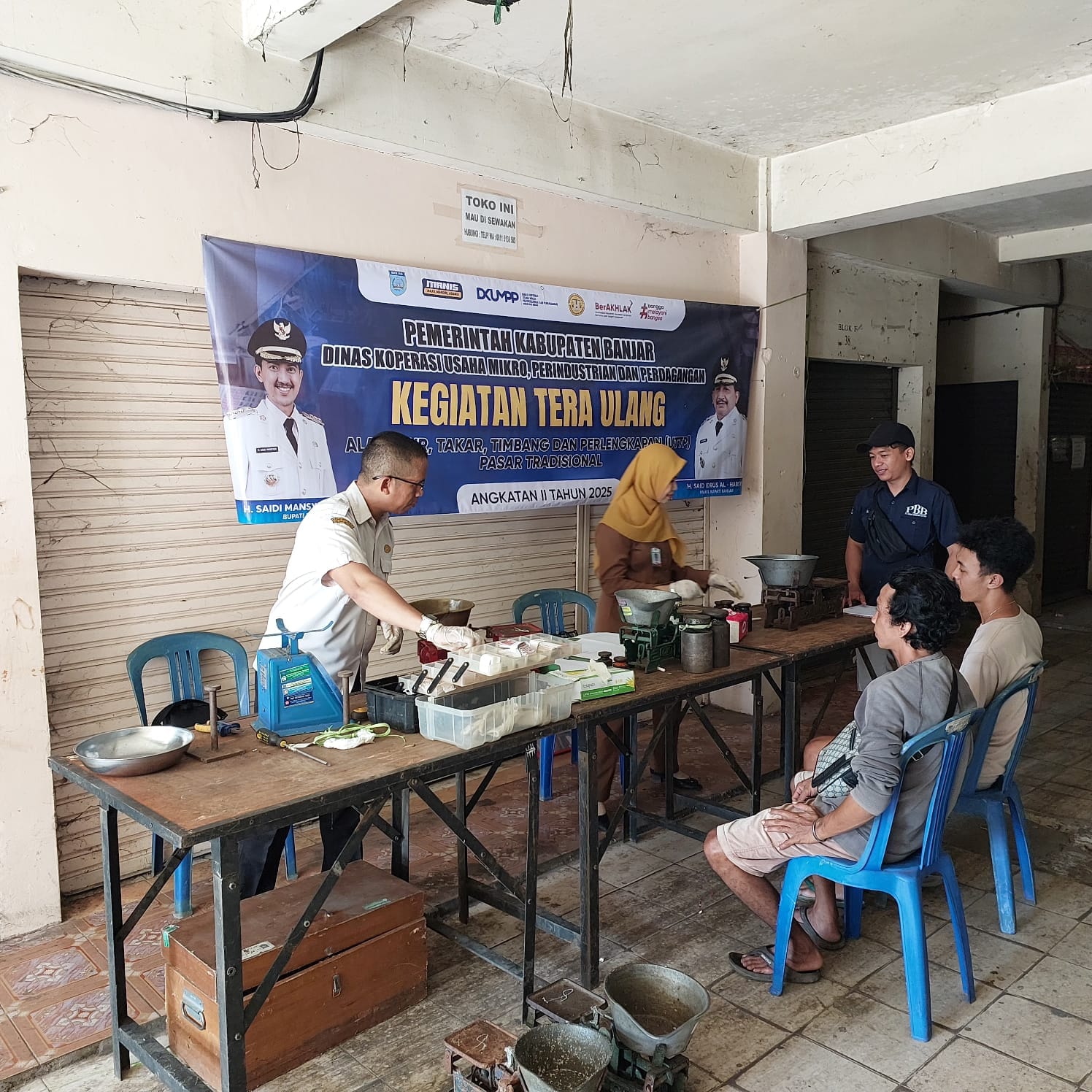 PENGECEKAN: Petugas DKUMPP Banjar melakukan tera ulang timbangan pedagang di Pasar Ahad, Kertak Hanyar, Senin (8/9) siang.