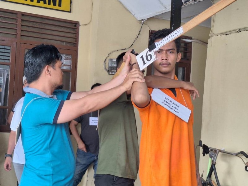 REKA ULANG: Tersangka memeragakan bagaimana dia membacok korban dengan sajam.