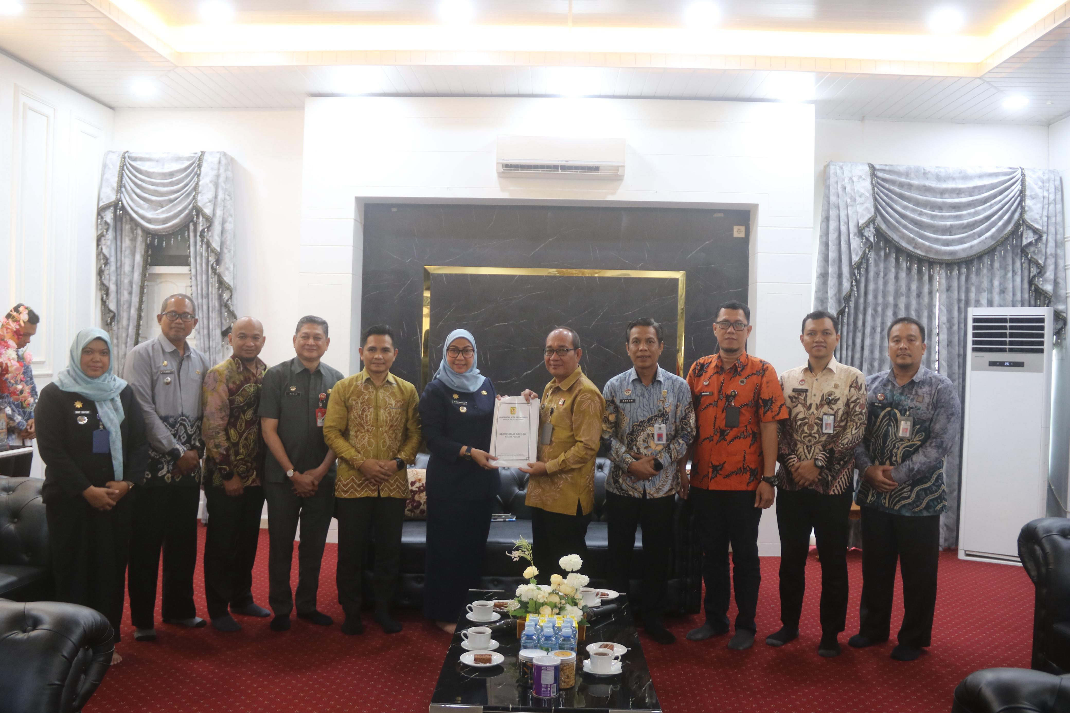 SIMBOLIS:Kepala Kanwil Kemenkum Kalsel, Alex Cosmas Pinem dan jajaran menerima SK dan menyerahkan STR Posbankum kepada Wali Kota Banjarbaru, Hj Erna Lisa Halaby, Kamis (11/9/2025).