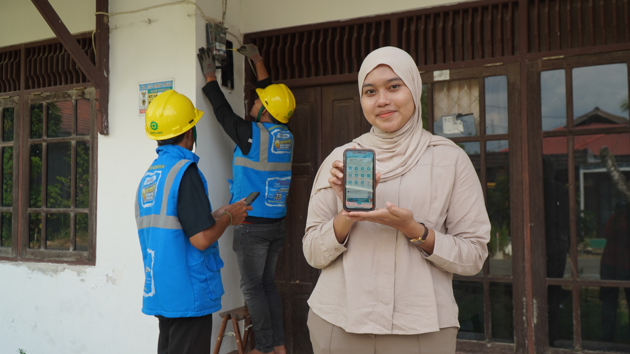 PRAKTIS: Salah satu pelanggan PLN memperlihatkan aplikasi PLN Mobile yang memudahkannya dalam proses tambah daya.