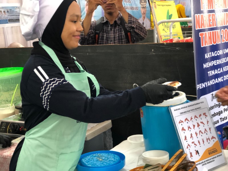 MEMASAK: Salah satu juru masak dari kalangan disabilitas tuli saat menunjukkan keterampilan memasaknya di Expo Koperasi dan UMKM di Lapangan dr Murdjani Banjarbaru.