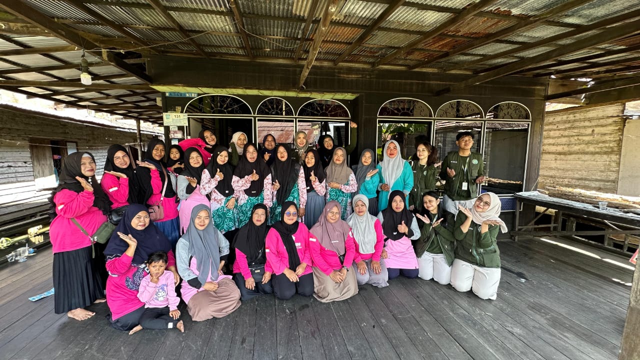 ABADIKAN MOMEN: Para dosen dan mahasiswa UNISM Banjarmasin foto di salah satu rumah warga desa Tandipah saat kegiatan PKM.