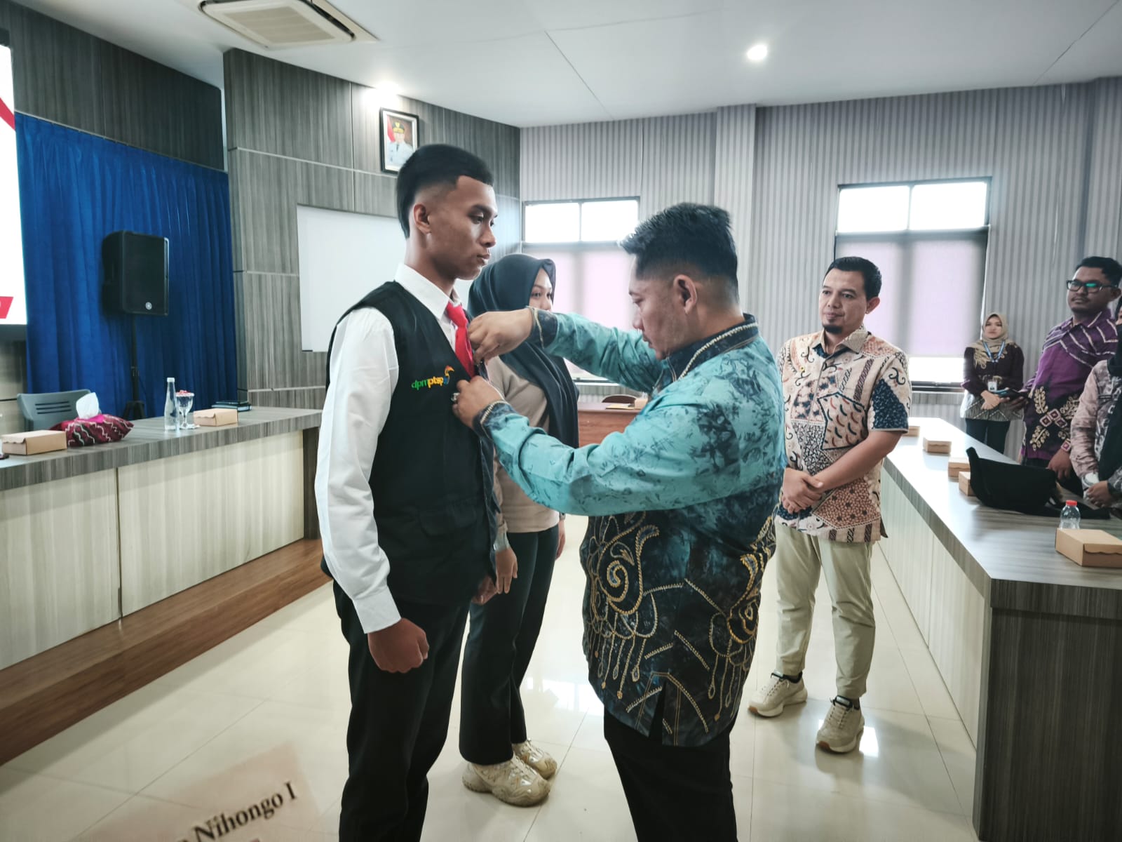 SEREMONI:Bupati Kabupaten HST, Samsul Rizal menyematman pin ke peserta Pelatihan Menjahit dan Berbahasa Jepang di Aula Bappelitbangda, Kamis (19/9/2025) pagi.
