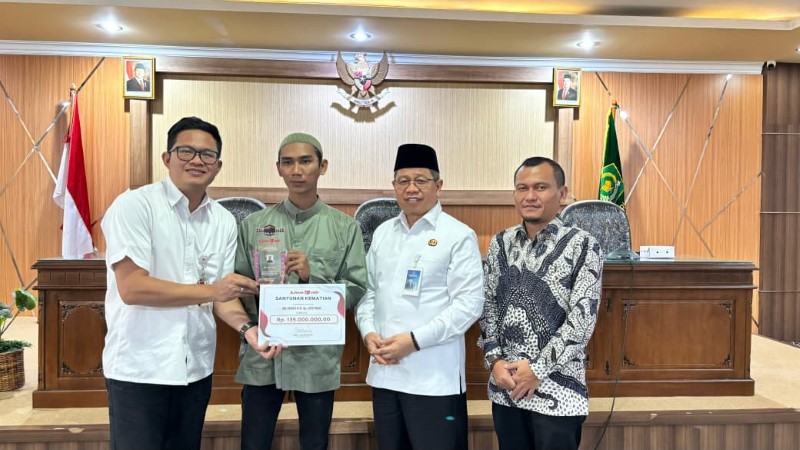 EXTRA COVER: Direktur Produksi Lion Air Capt Rachmat Diansyah Putra menyerahkan santunan senilai Rp135 juta kepada anak almarhum Lutfi Inani, jemaah haji Kloter BDJ 10 yang wafat di pesawat.
