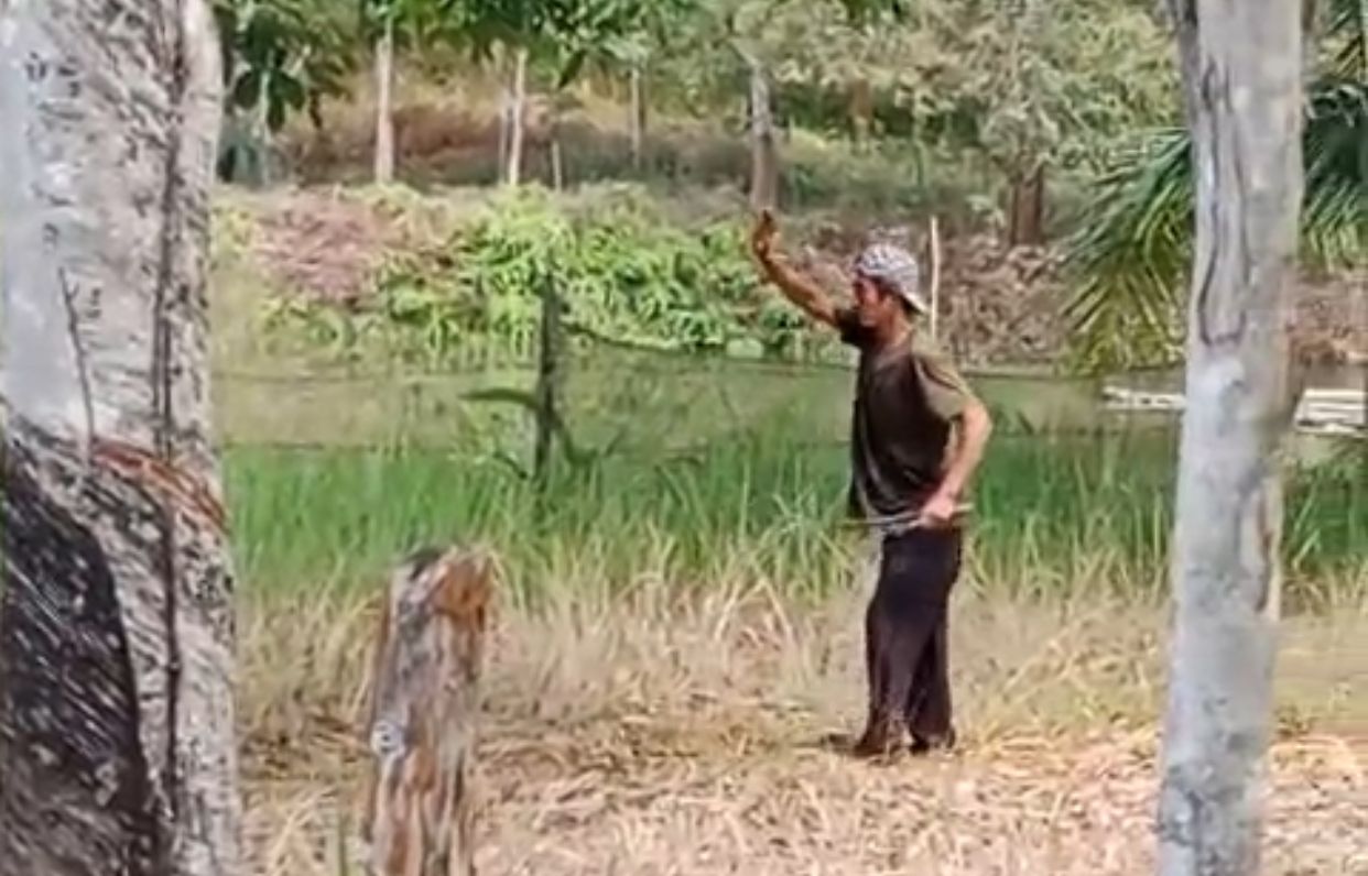 AGRESIF: Pelaku Basruni terlihat membawa parang saat hendak diamankan polisi di Batulicin, Jumat (19/9). (Foto: Tangkapan layar Video PKJR Tanah Bumbu)