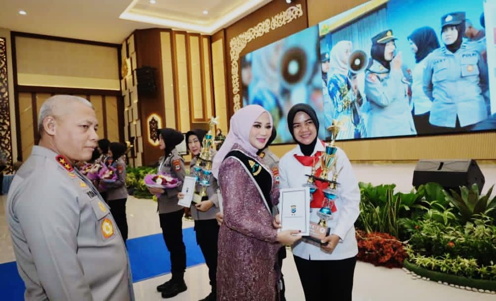 MOMEN:Istri Kapolda Kalsel, Yenny Yudha didampingi Kapolda Kalsel, Irjen Pol Rosyanto Yudha Hermawan menyerahkan trofi kepada Polwan HSU, Aipda Rizky Amalia.