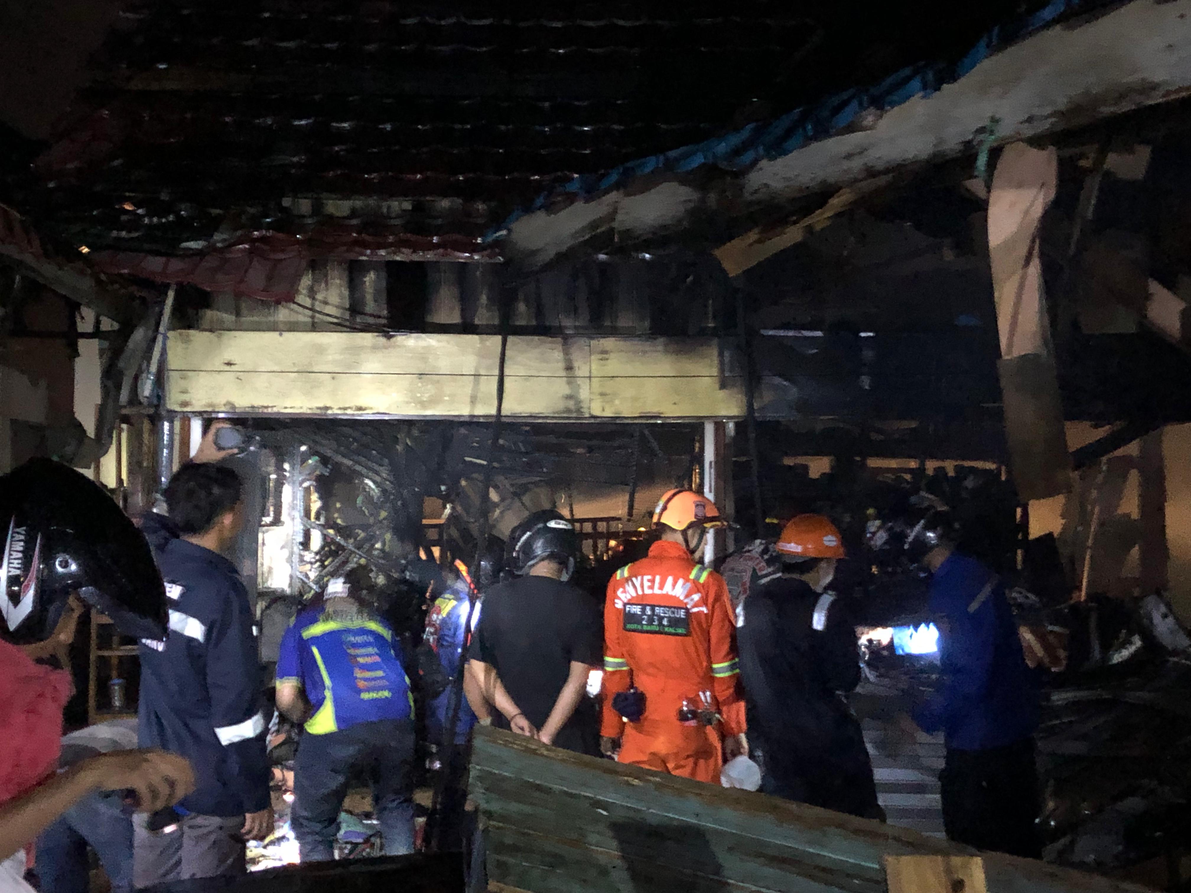 MASIH TERBAKAR: Situasi pendinginan pasar belakang Limbur Raya Kotabaru. Foto: Jumain/ Radar Banjarmasin.