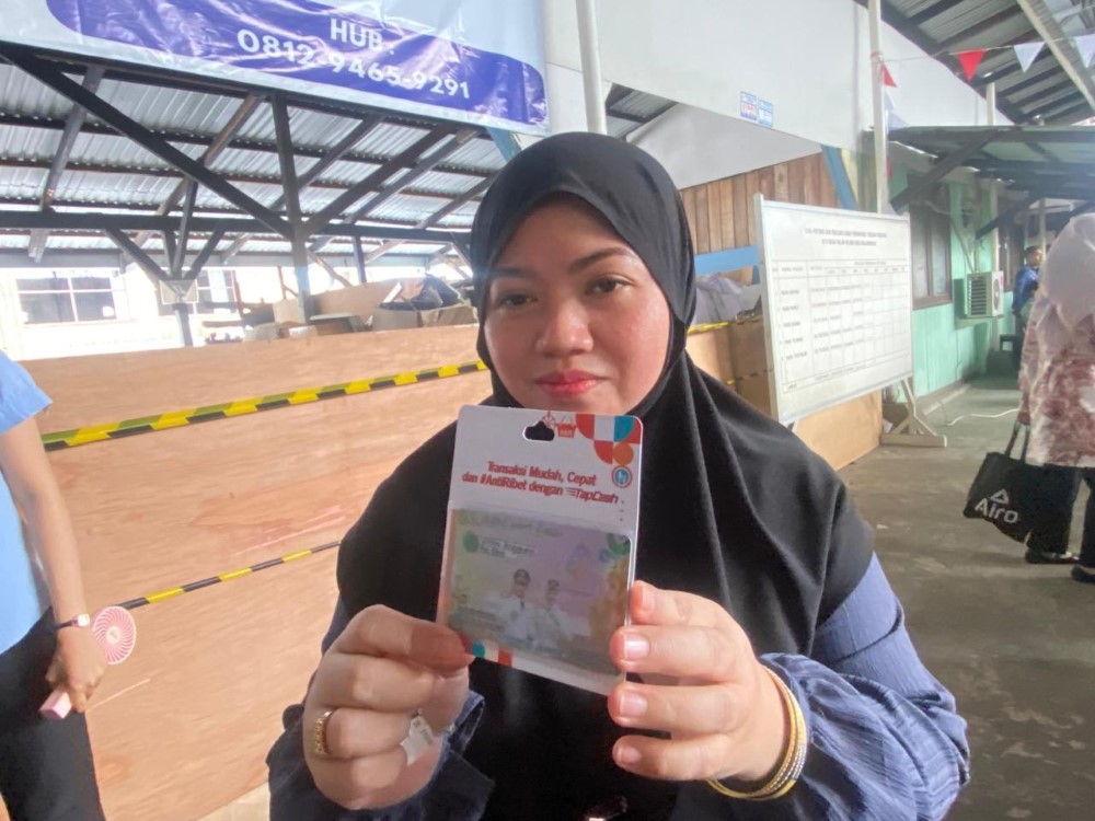 KARTU E-MONEY: Pedagang di pasar tradisional di Banjarmasin menunjukkan kartu tapcash bank milik BUMN.