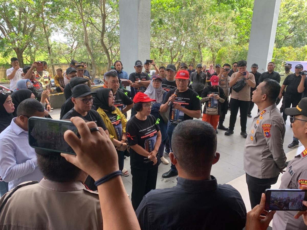 Seorang perwakilan pemilik condotel menyampaikan tuntutan dengan suara lantang di depan gedung Grand Banua, Senin (30/9). Aksi ini mendapat pengawalan ketat aparat kepolisian.