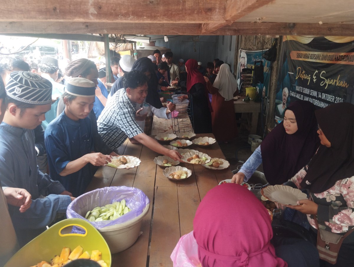 MAKAN GRATIS: Jemaah salat Jumat saat menikmati makanan gratis yang disediakan pengurus Masjid Jami Baiturrahman di Pembatuan, Jumat (3/10).