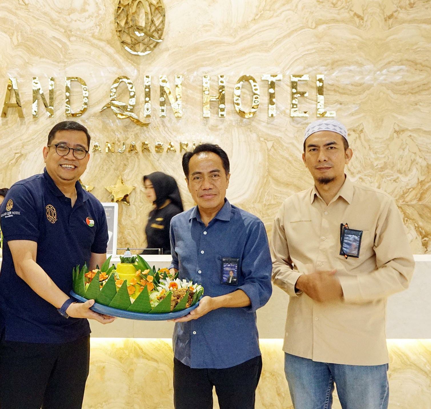 SELAMAT ULTAH: Dirut Radar Banjarmasin, H Suriansyah Achmad (tengah) menyerahkan tumpeng kepada GM Grand Qin dan Qin Hotel Banjarbaru, Kholid Basyaiban, Senin (6/10/2025).