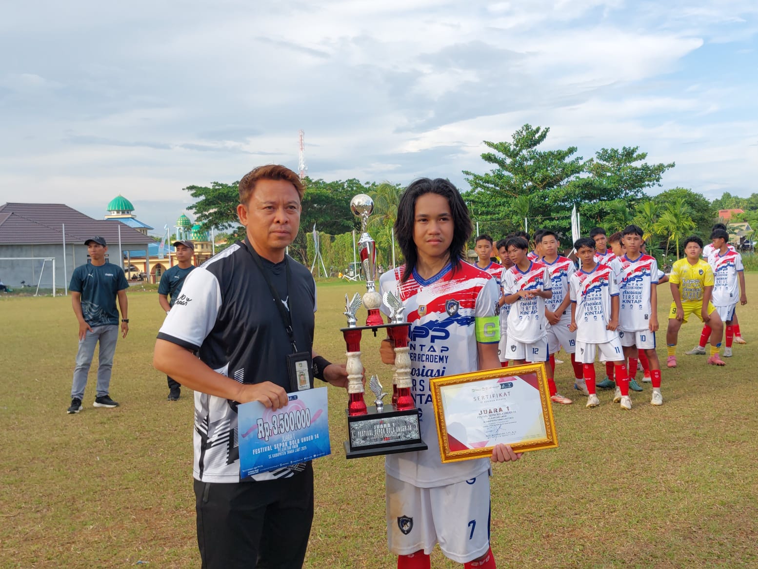 JUARA: Kapten tim UPP Kintap Mukti Al-Kahfi saat menerima trofi, piagam penghargaan dan uang pembinaan juara satu dari Dispora Tala.