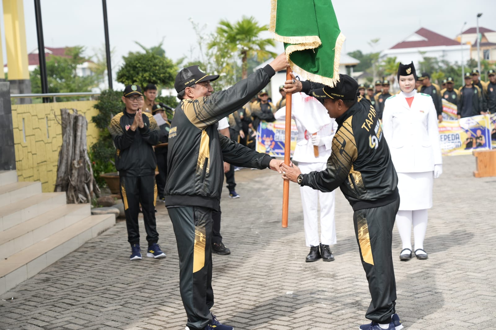 PELEPASAN ATLET: Pj Sekda Tapin Unda Absori menyerahkan bendera Tapin ke Ketua KONI Tapin H Misran. Foto Rasidi Fadli