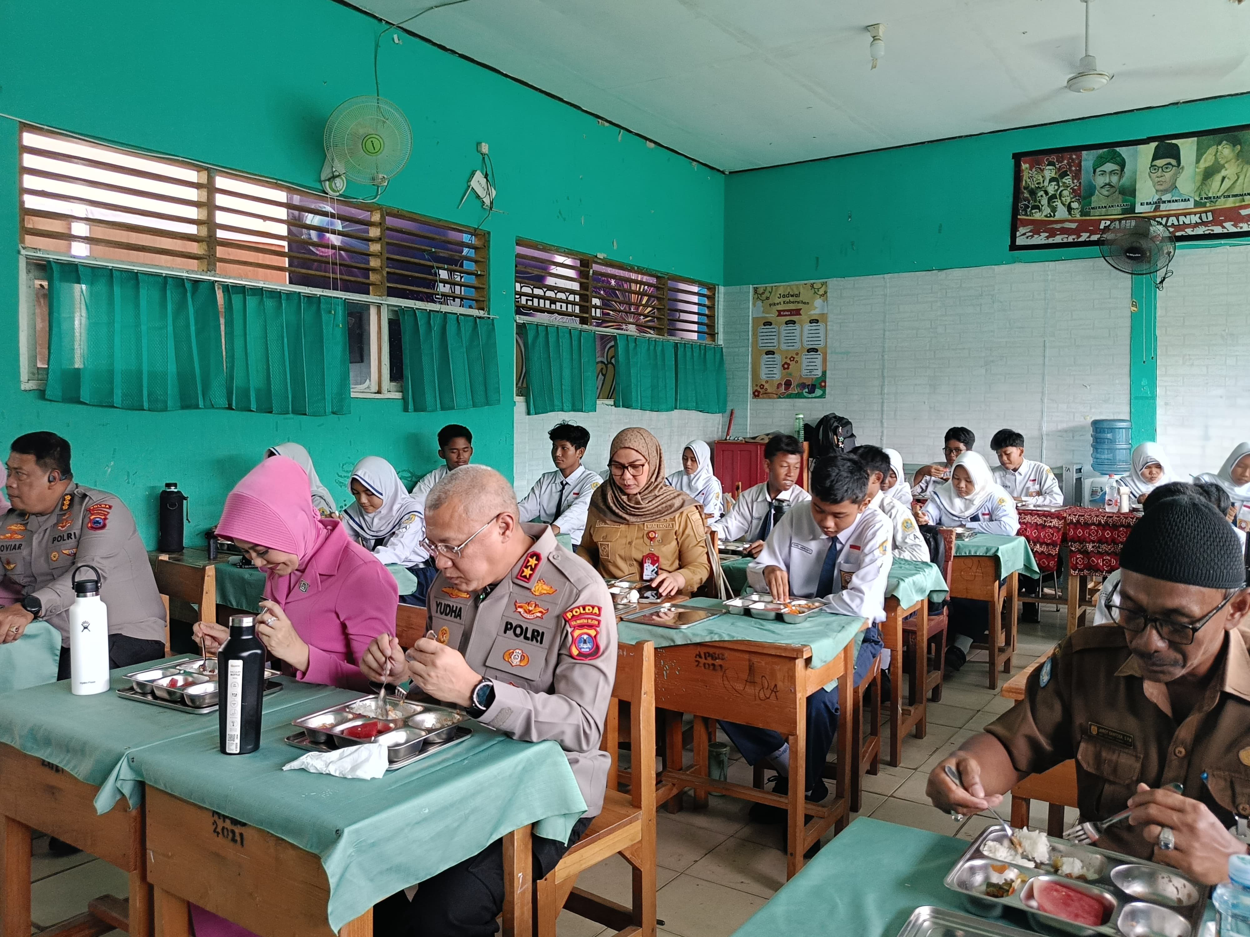 Kapolda Kalsel, Ketua Bhayangkari Kalsel, Dan Wali Kota Banjarbaru Sedang Menyantap Hidangan Makanan Bergizi Gratis Di Salah Satu Ruang Kelas SMP Negeri 5 Banjarbaru (Sheila Farazela/Radar Banjarmasin
