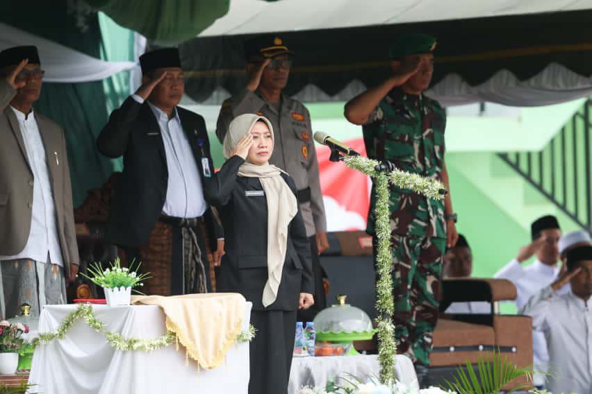 HORMAT: Sekda Tanah Bumbu Yulian Herawati memberi penghormatan kepada Sang Saka Merah Putih pada upacara peringatan Hari Santri 2025 di Ponpes Azzikra DDI Kersik Putih.
