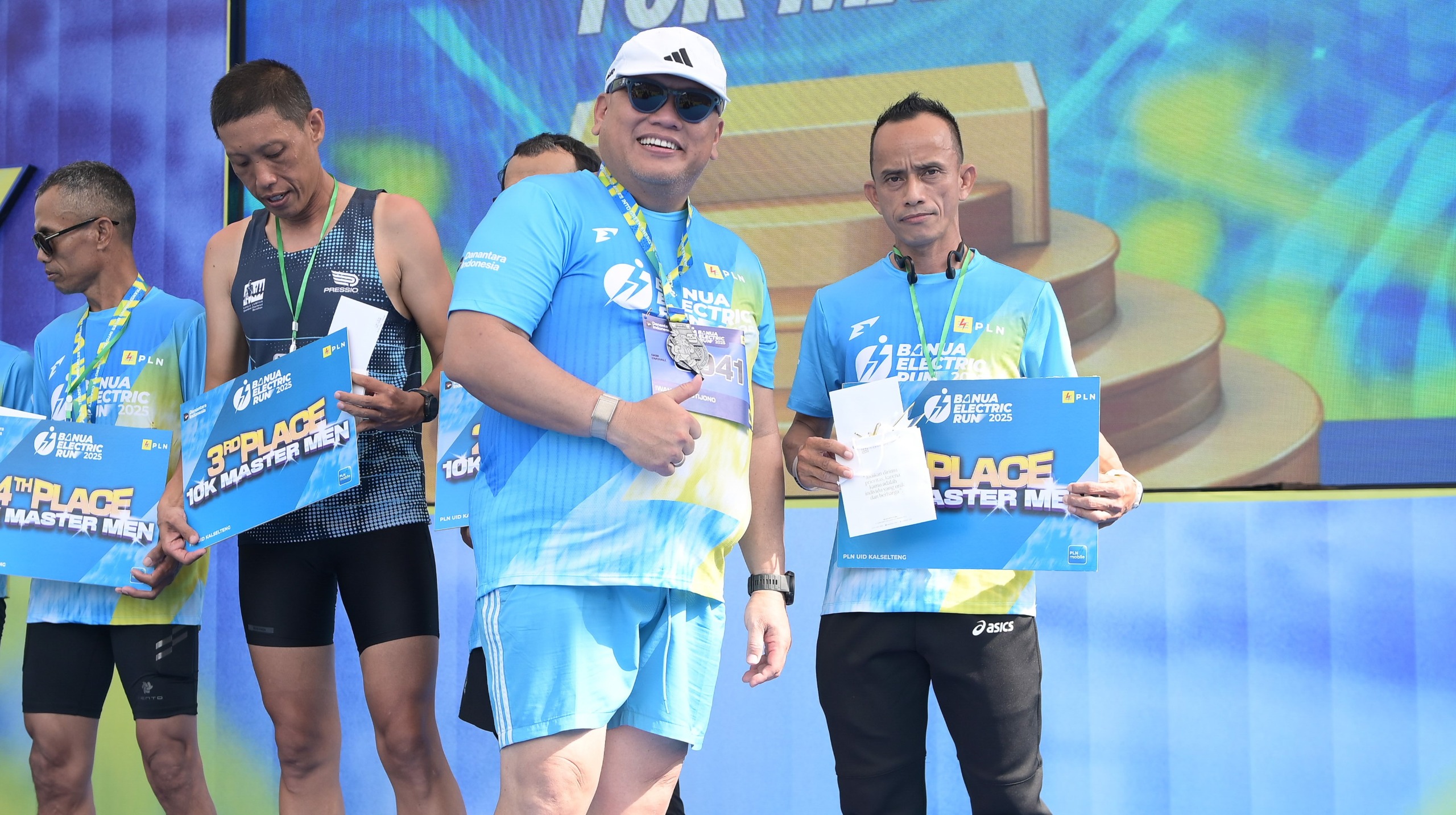 BANGGA:Penyerahan hadiah oleh General Manager PLN UID Kalselteng, Iwan Soelistijono kepada Masiang juara pertama kategori Master Male 10K.