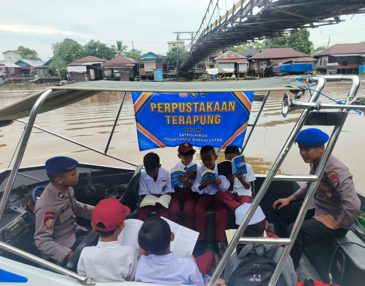 UPAYA:Anggota Polairud Polres HSU melakukan kegiatan pemberdayaan masyarakat dengan menghadirkan perpustakaan terapung bagi anak pesisir Sungai Barito.