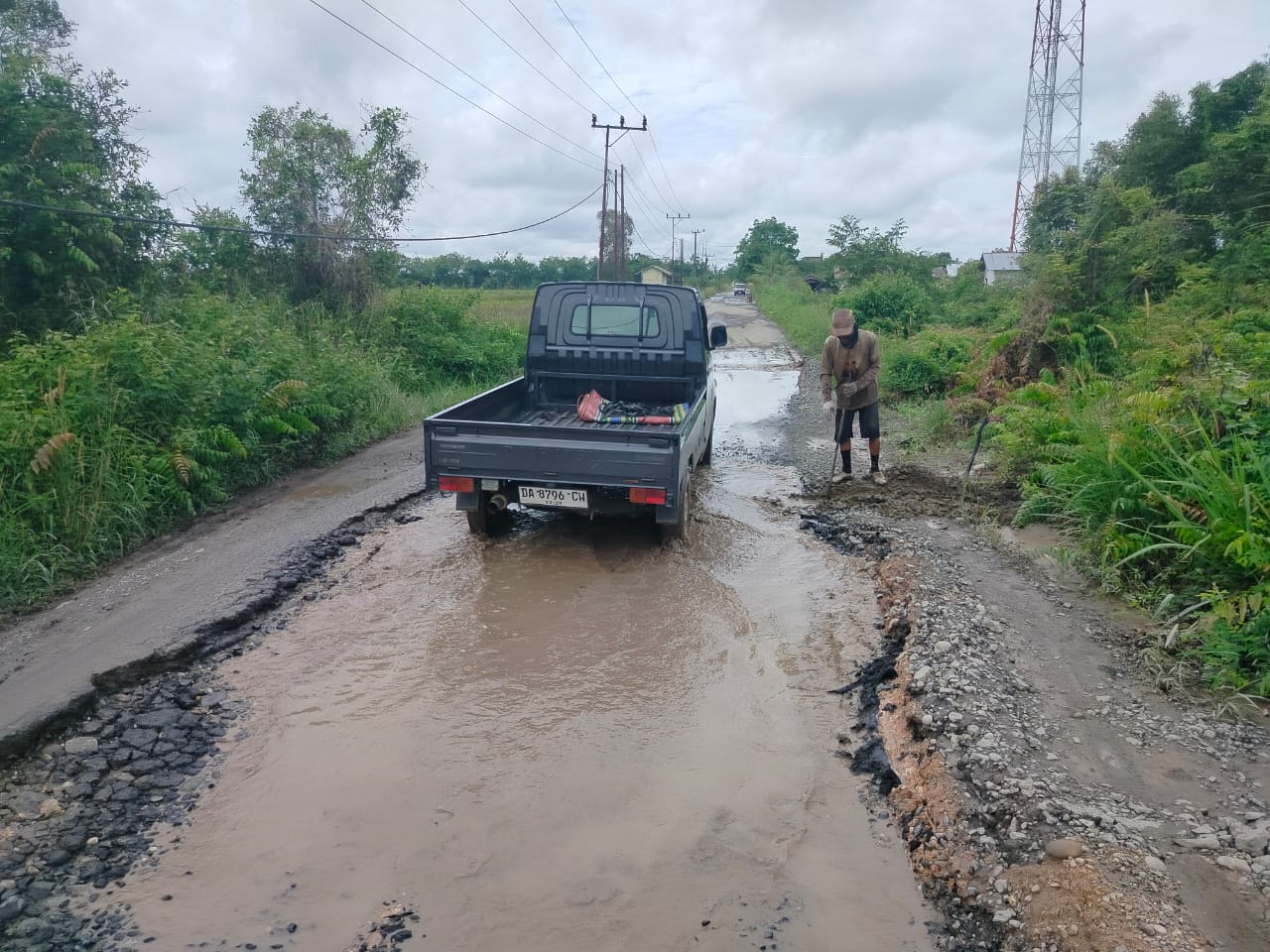 INISIATIF:Warga Gandaria, M Darkasi mengorek tanah untuk mengurangi genangan air di salah satu ruas jalan poros Anjir Pasar-Marabahan.