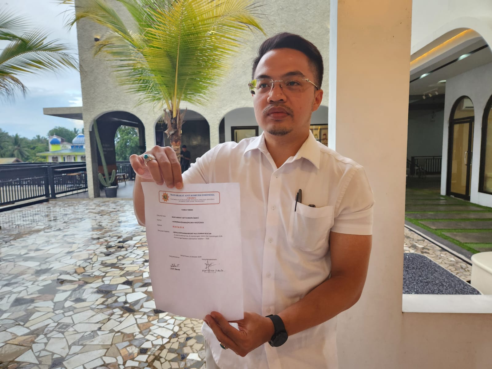 TUNJUKKAN : Kuasa Hukum MAKI Marselinus Edwin menunjukkan berkas Dumas yang dilaporkan ke Polres HSS. Foto Salahudin/Radar Banjarmasin