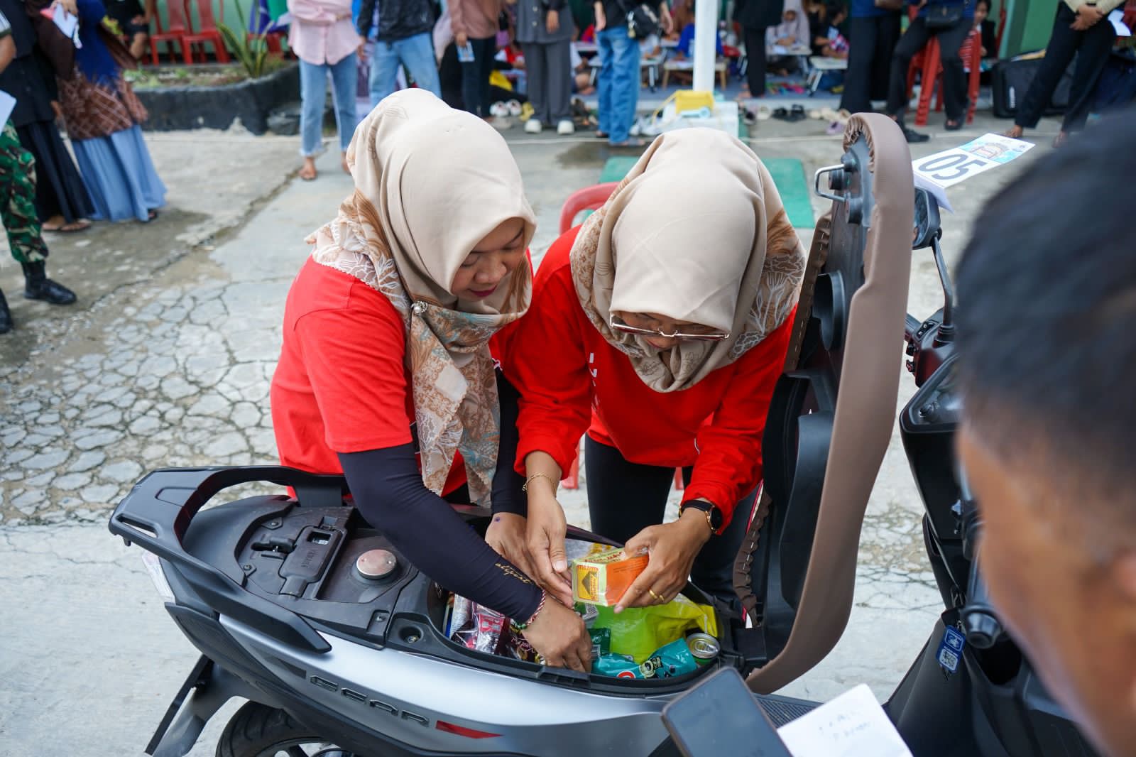 LOMBA:Ibu-ibu berlomba memasukan sebanyak mungkin barang belanjaan ke dalam bagasi Yamaha Gear Ultima.