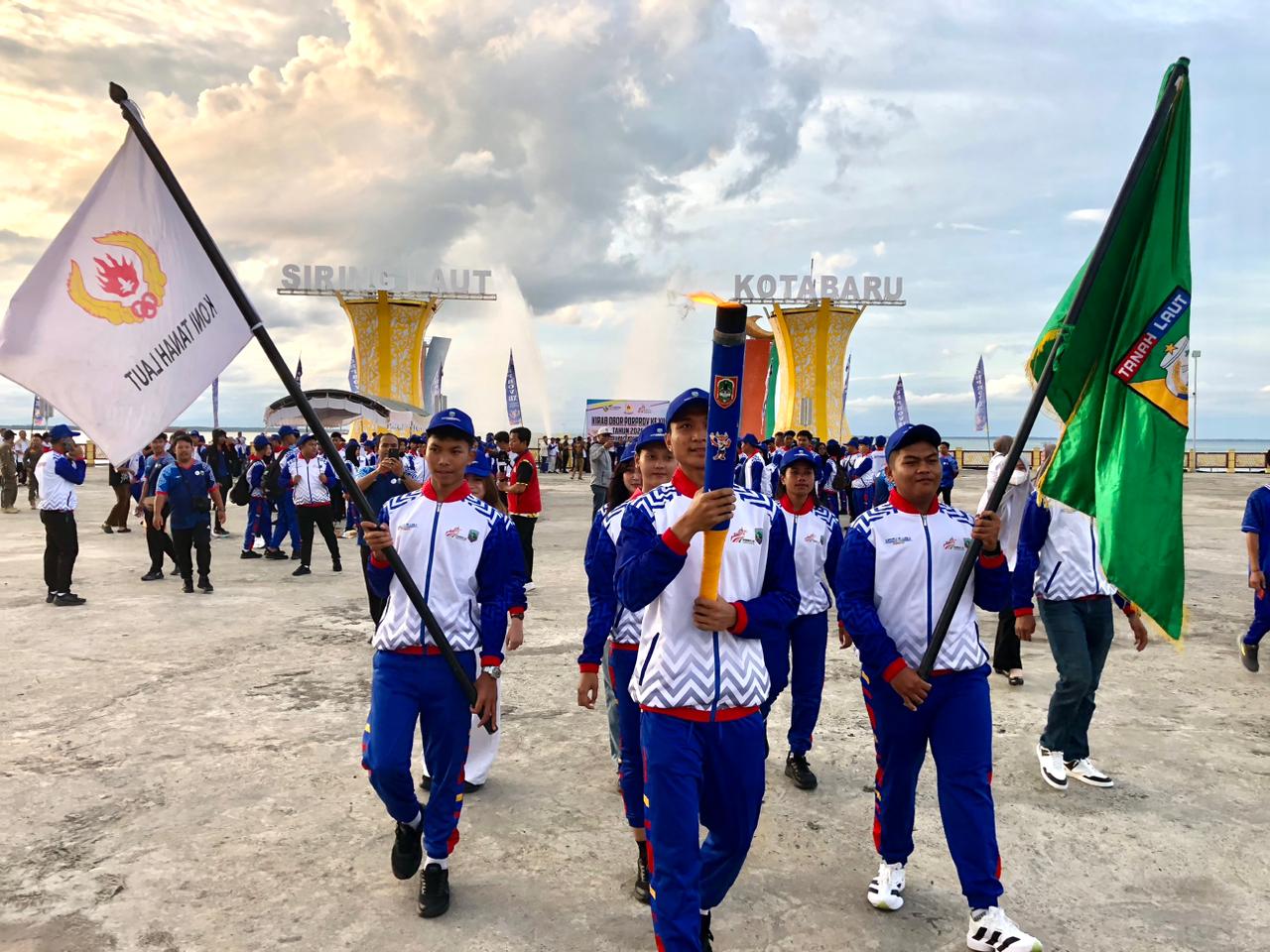 DIARAK: Ratusan atlet kontingen Kotabaru mengarak obor Porprov keliling kota Bumi Saijaan. Foto: Jumain/ Radar Banjarmasin.