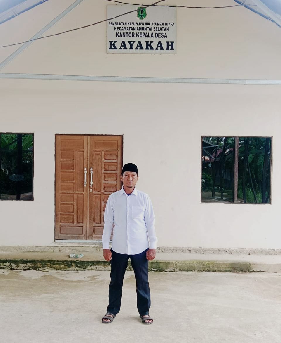 PUNYA SEMANGAT: Kepala Desa Kayakah, Mursidi berfoto di depan kantor kades.