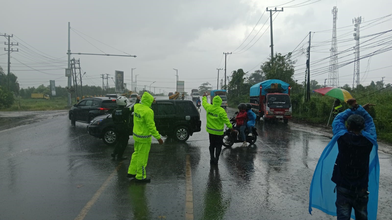 MENGHALAU TRUK:Sejumlah truk memanfaatkan kondisi hujan, namun petugas tetap berjaga dan memerintahkan pengemudi untuk putar balik arah dan mencari tempat parkir.