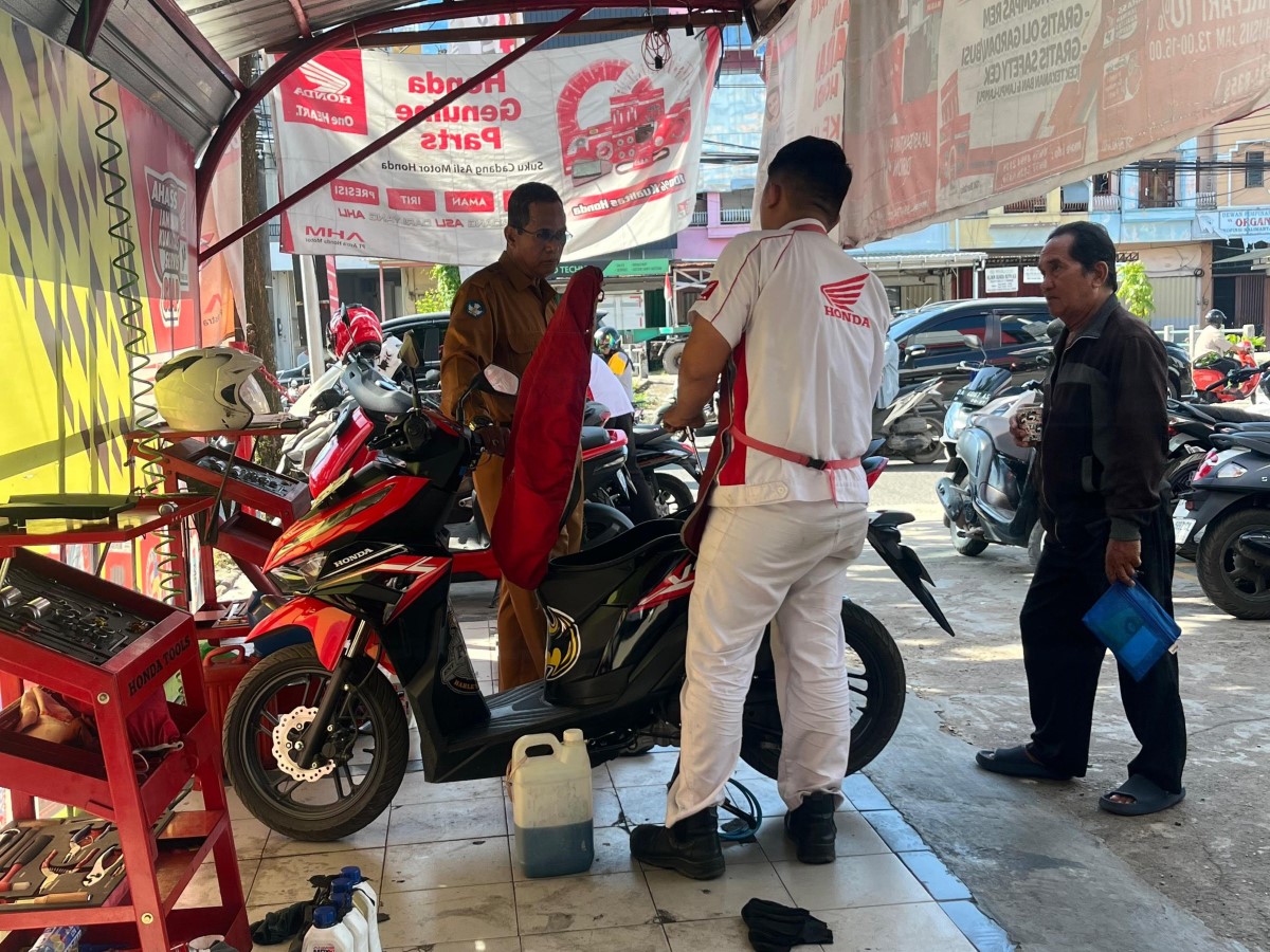 MASUK BENGKEL: Salah seorang warga Banjarmasin membawa motornya ke bengkel, diduga gara-gara BBM jenis Pertalite, Senin (3/11)