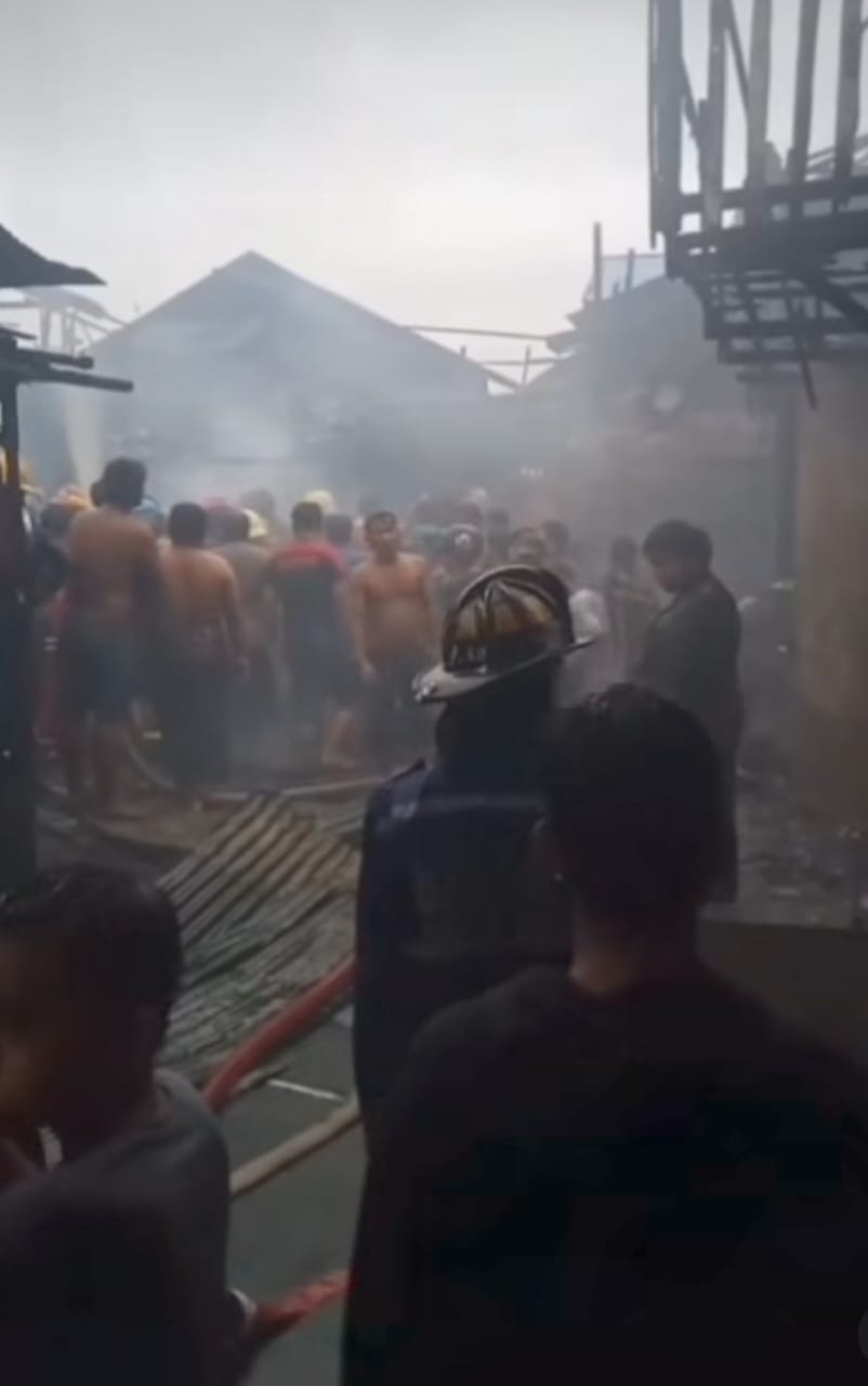 TERBAKAR: Para anggota pemadam berupaya memadamkan sisa-sisa kebakaran dan mengevaluasi korban.
