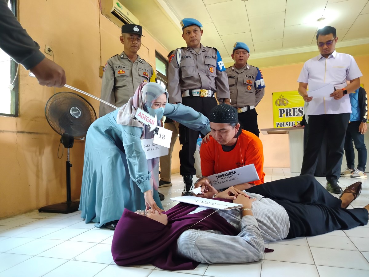 BRUTAL: Andi Julianto alias Encek memeragakan cara menghabisi korban bidan Rahmaniah dengan brutal.