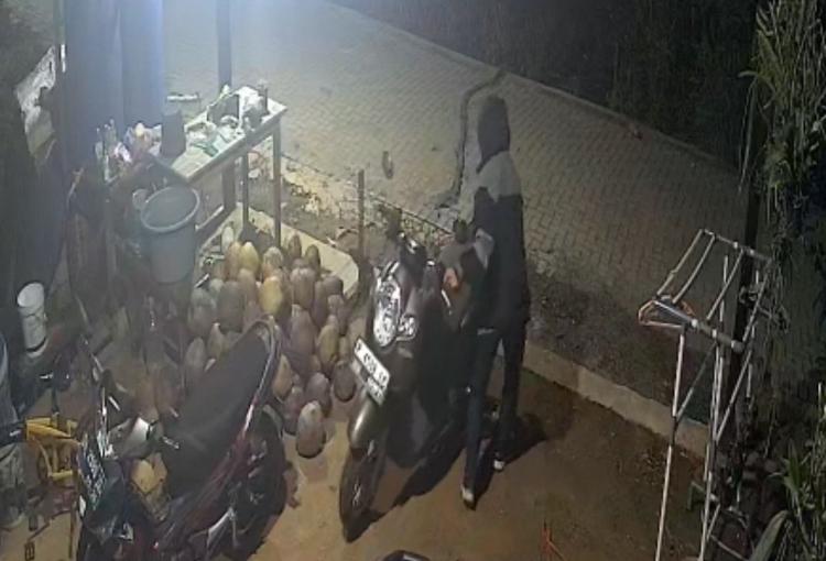 Tangkapan layar rekaman CCTV yang memperlihatkan pelaku saat mengeluarkan motor dari garasi rumah korban.