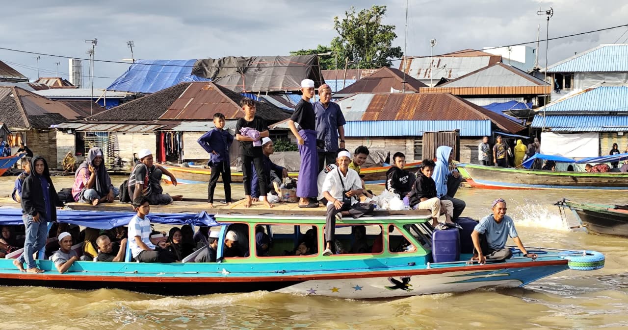 HINDARI MACET: Kapal kelotok penuh jemaah melintasi Sungai Martapura menuju kawasan Sekumpul.