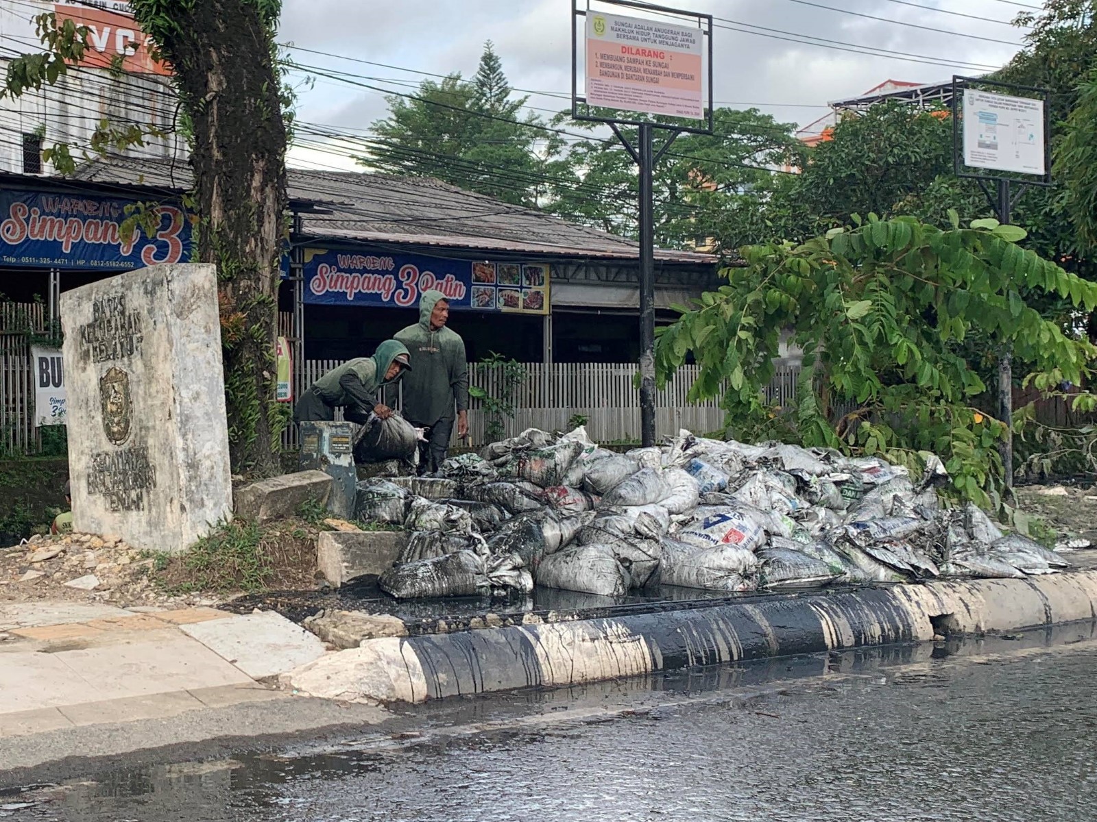HALANGI PEJALAN KAKI:&nbsp;Tumpukan karung berisi lumpur hasil pengerukan sungai memenuhi trotoar di kawasan Jalan Ahmad Yani Km 2 Banjarmasin Timur. Foto diambil Rabu (12/11).
