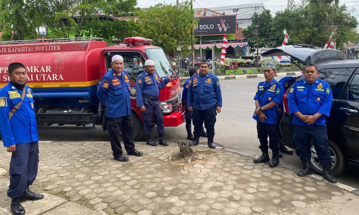 KEKURANGAN SARPRAS: Kabid Linmas dan Damkar HSU H Barkat Syarul Kalam (dua kiri) foto bersama personel dengan satu-satunya truk tangki milik Damkar HSU.