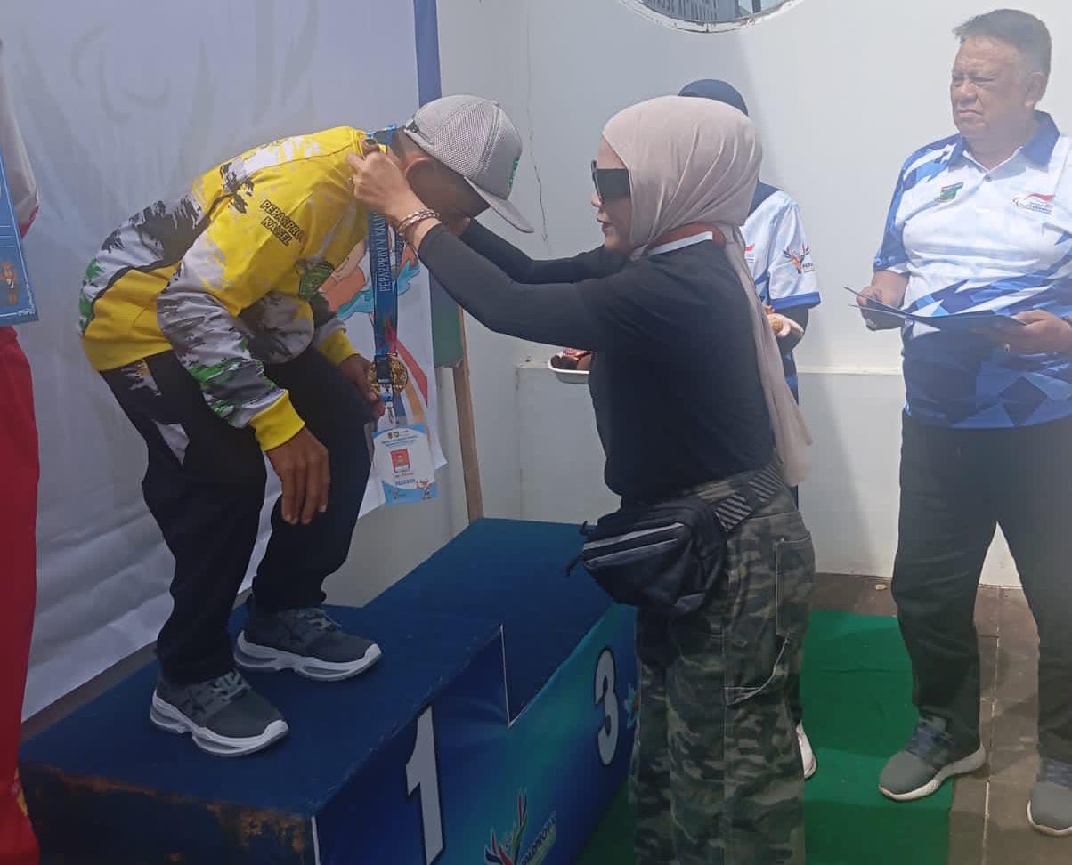 PENGALUNGAN MEDALI: Atlet Tapin menerima medali emas di cabor renang pada Peparprov Kalsel 2025. Selain itu, juga meraih medali perunggu di hari pertama.