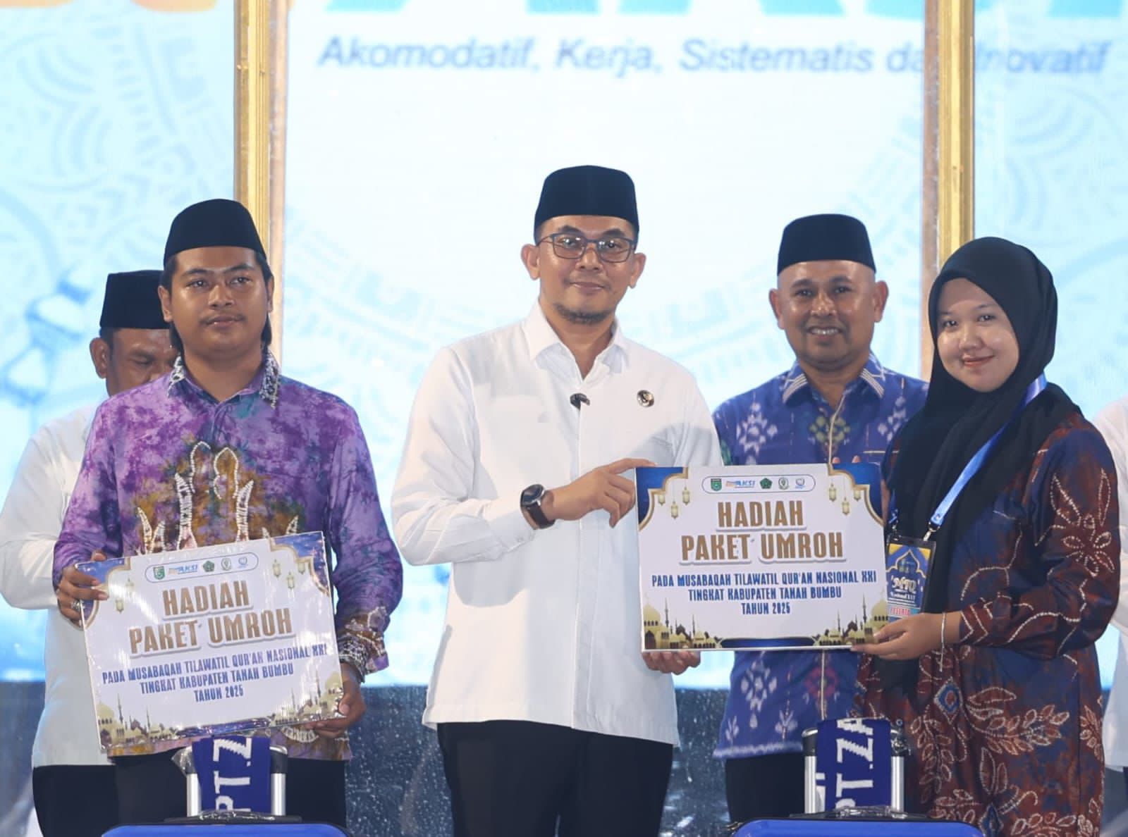HADIAH:Bupati Tanah Bumbu menyerahkan paket umrah kepada Kafilah Kecamatan Kusan Tengah yang menjadi juara MTQ XXI 2025 Kabupaten Tanah Bumbu, Jumat (21/11/2025).