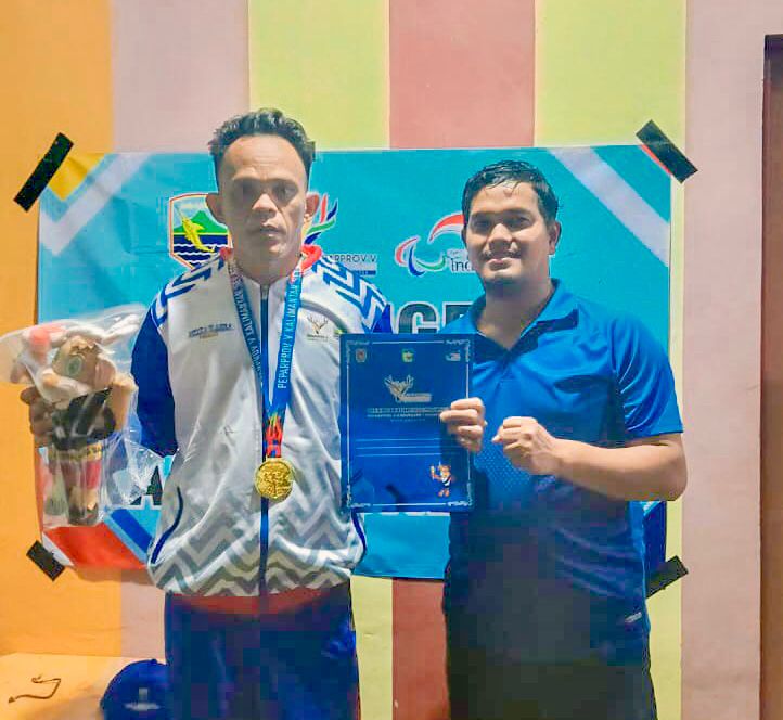 TERHARU: Agus Salim dan pelatihnya terharu memperlihatkan emas yang diraihnya.