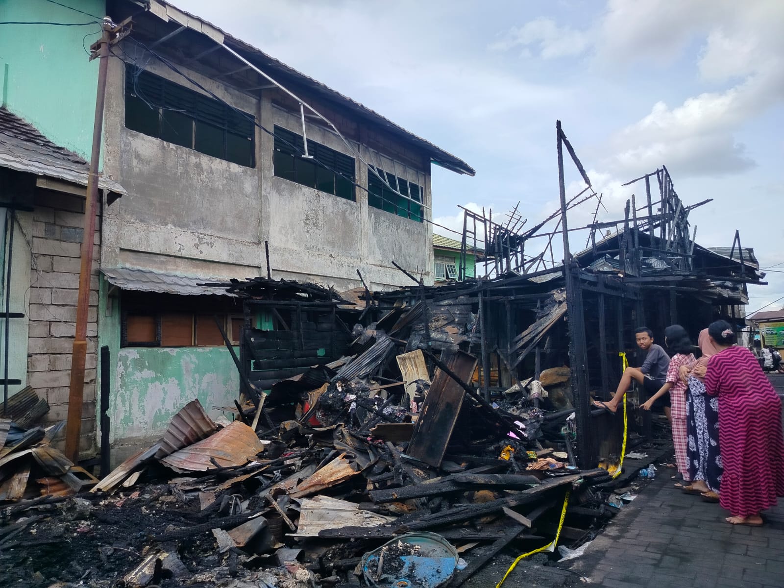TINGGAL PUING: Rumah warga yang menjadi korban kebakaran ludes terbakar, begitu juga kusen dan kaca gedung SMAN 4 Banjarmasin.