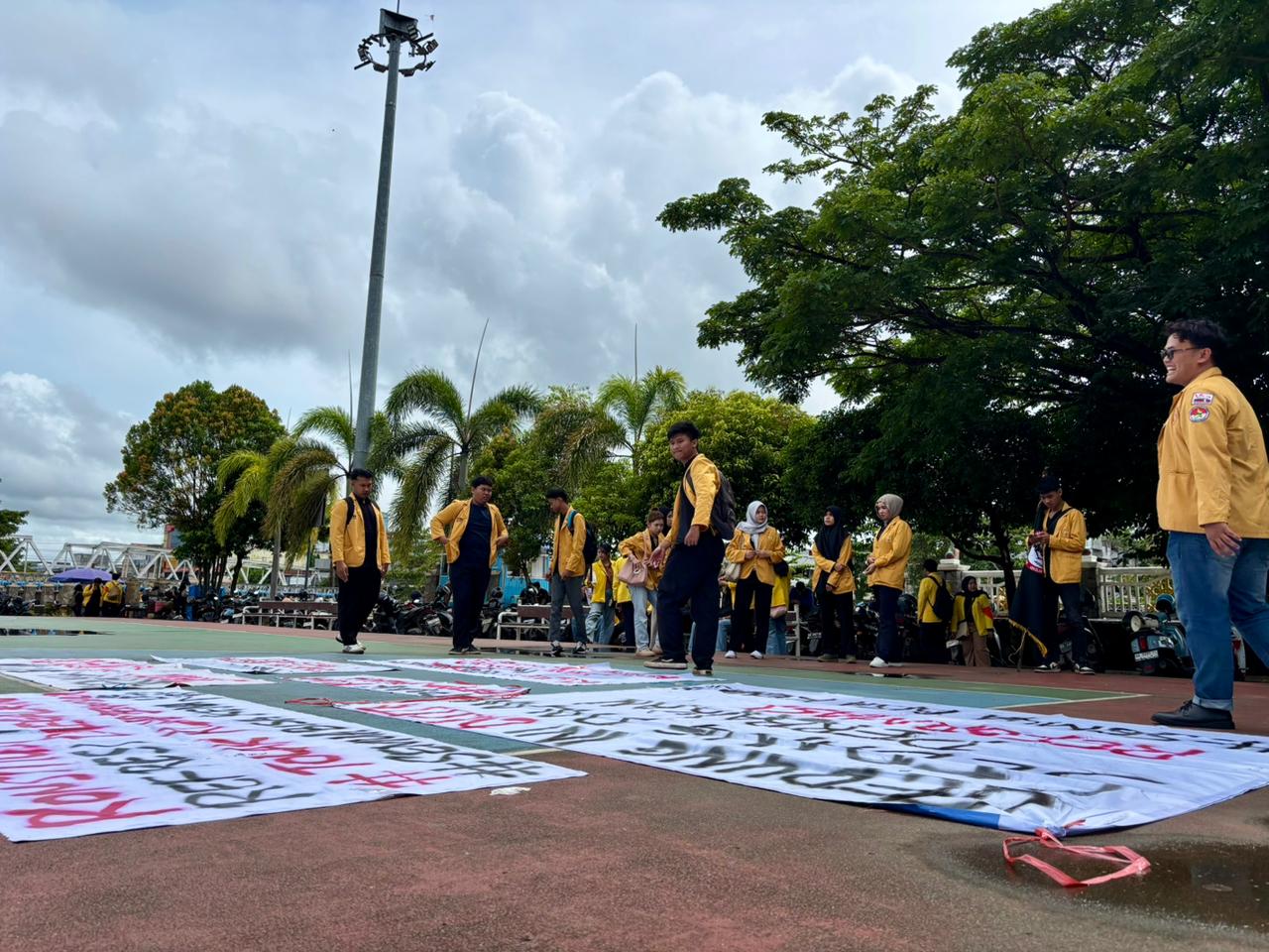KUMPUL DI PATUNG BEKANTANG: Para mahasiswa menyiapkan atribut seperti bendera dan spanduk untuk demo menolak KUHAP ke DPRD Kalsel.