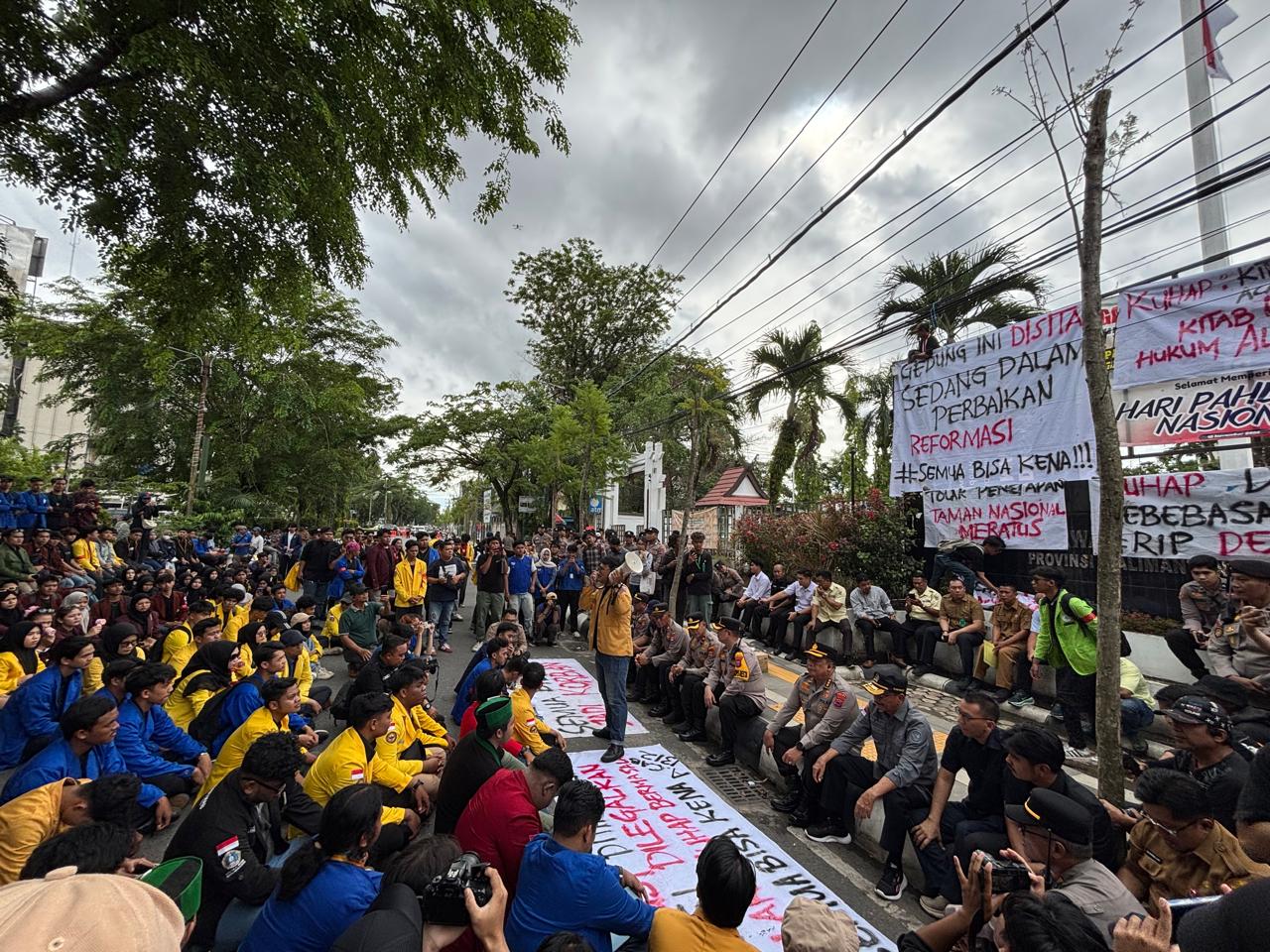 DUDUK LESEHAN: Para mahasiswa yang demo menolak KUHAP berorasi di DPRD Kalsel. Mereka hanya mau ditemui Supian HK.