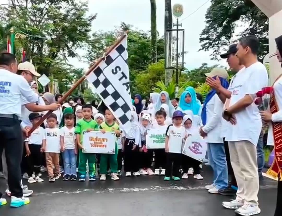MOMEN:Kepala Disdikbud Kabupaten HSU, Rahman Heriadi melepas kegiatan jalan sehat memperingati Hari Anak Sedunia dan Hari Guru Nasional di Halaman Kantor Bupati HSU, Minggu (23/11/2025).