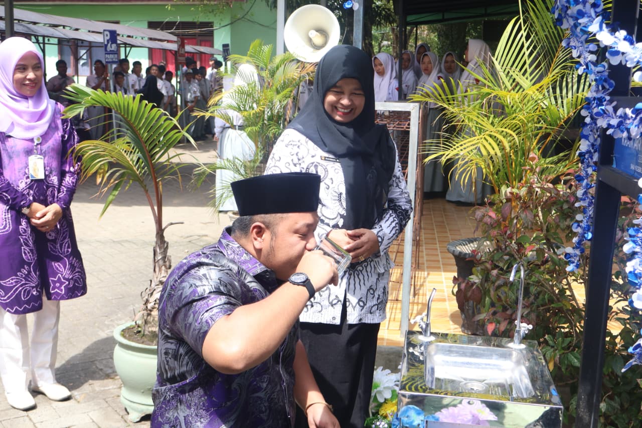 MINUM: Gusti Rizky mencicipi air dari kran siap minum sambil duduk, saat peresmian di SMAN 3 Banjarbaru.