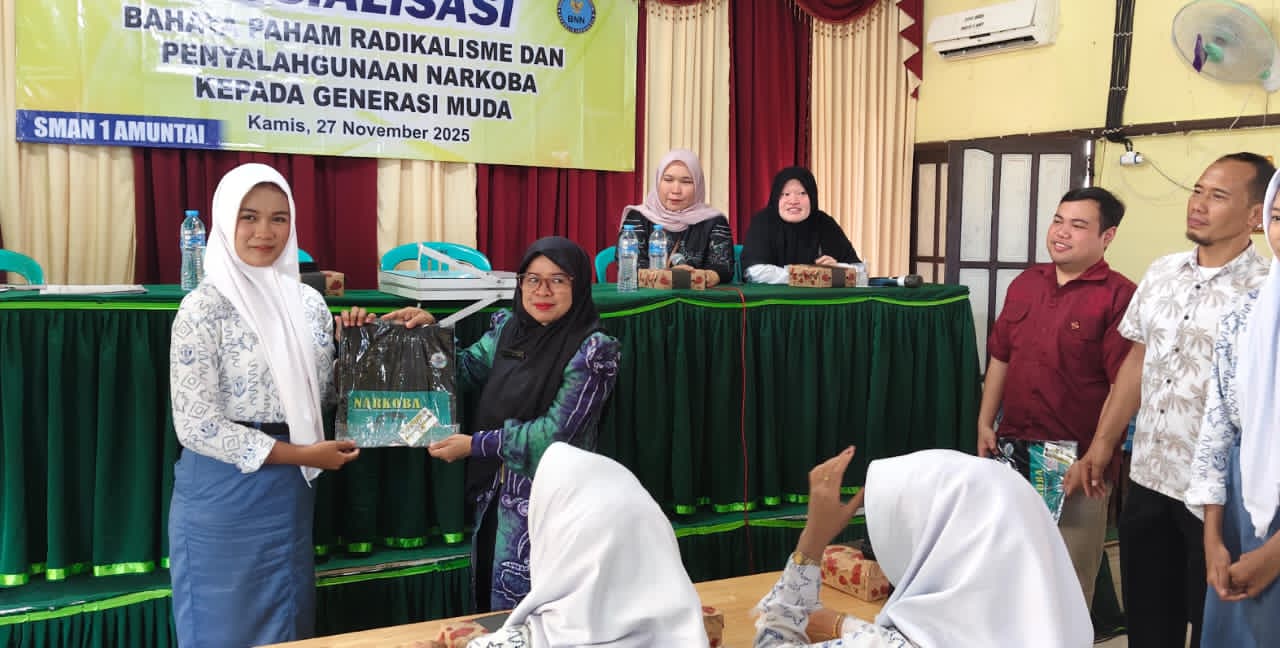 APRESIASI:Kabid Ekososbud Bakesbangpol HSU, Dr Harmiati menyerahkan kaos anti narkoba dari Satres Markoba Polres HSU pada siswa dengan pertanyaan terbaik di Aula SMAN 1 Amuntai, Kamis (27/11/2025).