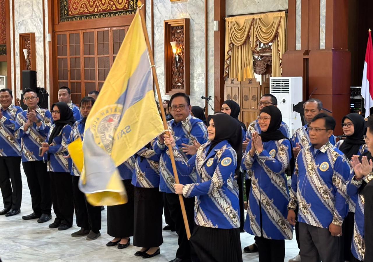 Ketua IKA Unair Kalsel, drg Ellyana Trisya mengibarkan pataka IKA Unair secara simbolis setelah resmi dilantik oleh pengurus pusat IKA Unair di Mahligai Pancasila, Sabtu, 9 November 2025.